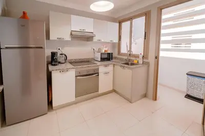 a kitchen with white cabinets and a stainless steel refrigerator at Prestige de luxe avec piscine in Marrakech