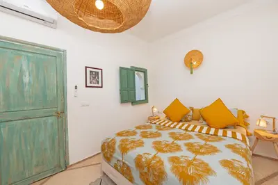 a bedroom with a bed and a green door at Riad E&J Marrakech Médina 5 ch climatisées, piscine chauffée, EXCLUSIF in Marrakech