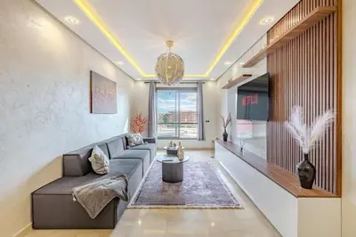 a living room with a couch and a tv at Studio Haut de Gamme in Marrakech