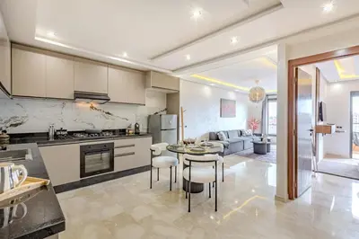 a kitchen and living room with a table and chairs at Studio Haut de Gamme in Marrakech