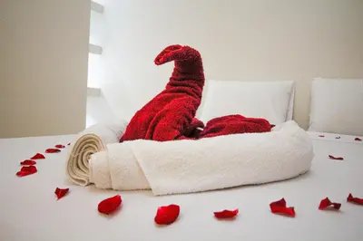 a red stuffed dinosaur sitting on a bed with roses at Redmoon Villa & Riad in Marrakech