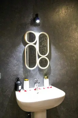 a bathroom with a sink and two mirrors on the wall at Redmoon Villa & Riad in Marrakech
