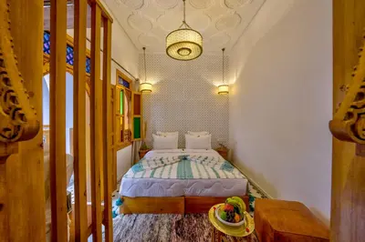 a bedroom with a bed and a table in a room at Riad AL-Ghazlan Hamam & Spa in Marrakech