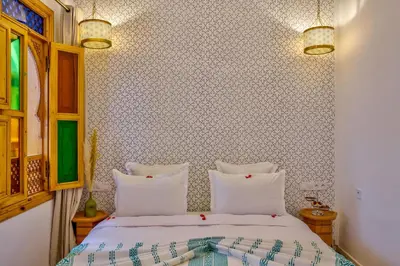 a bedroom with a bed with white pillows at Riad AL-Ghazlan Hamam & Spa in Marrakech