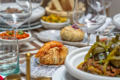 a table topped with plates of food and wine glasses at Riad AL-Ghazlan Hamam & Spa in Marrakech