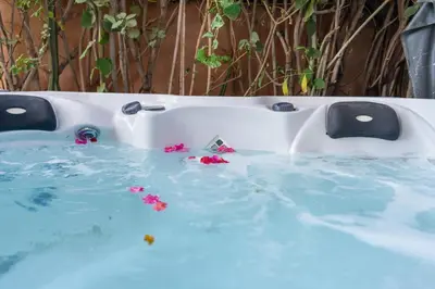 a bath tub filled with water with flowers in it at Villa centre Marrakech piscine sans vis-à-vis et Jacuzzi in Marrakech