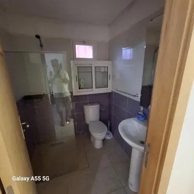 a woman standing in a bathroom with a toilet and a sink at Douira in Marrakech