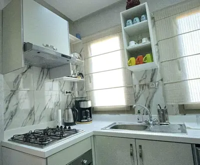 a white kitchen with a sink and a stove at Gone app Marrakech in Marrakech