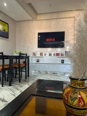 a restaurant with a table and a tv on the wall at Gone app Marrakech in Marrakech