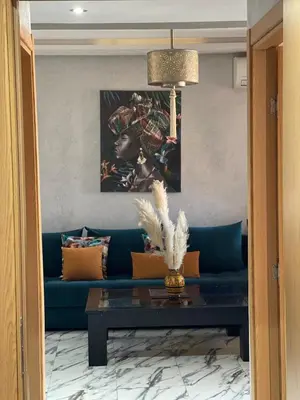 a living room with a blue couch and a table at Gone app Marrakech in Marrakech