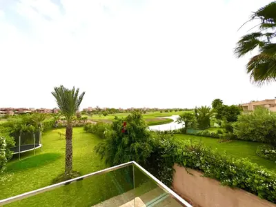 a view of a park with a palm tree at Nice Villa Prestigia golf city marrakech in Marrakech