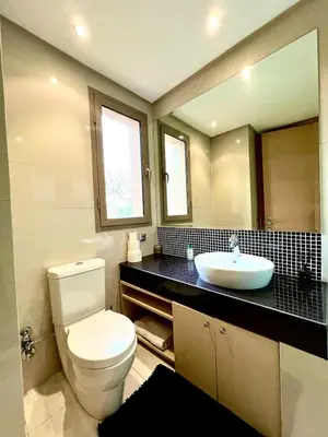a bathroom with a white toilet and a sink at Nice Villa Prestigia golf city marrakech in Marrakech