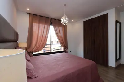 a bedroom with a pink bed and a window at Modern top floor apartment with balcony! in Marrakech