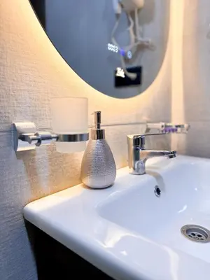 a bathroom sink with a round mirror above it at Stylish Escape Modern Comforts in Marrakech