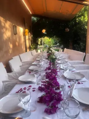 a long table with wine glasses and purple flowers on it at villa hibiscus marrakech in Marrakech