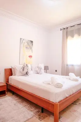 a bedroom with a large bed with white sheets at Refuge Peachy Guéliz et Confort in Marrakech
