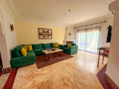 a living room with a green couch and a table at Riador in Marrakech