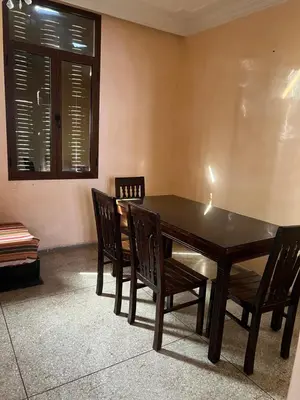 a dining room with a table and chairs and a window at dar shahd in Marrakech