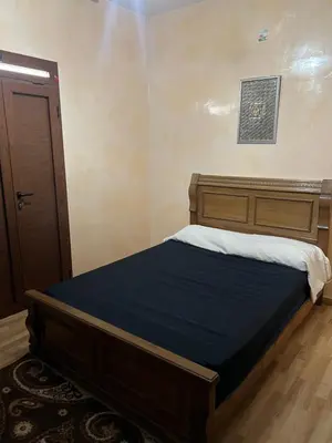 a bed in a bedroom with a wooden headboard at dar shahd in Marrakech