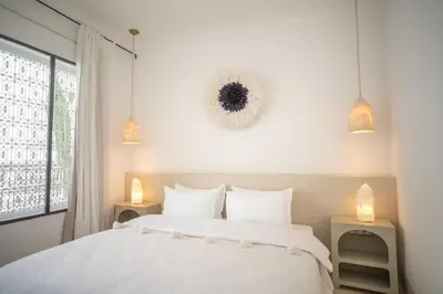 a bedroom with a large white bed with two lamps at Riad Dar Mimi in Marrakech