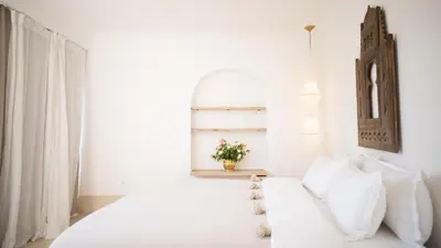 a white bedroom with a white couch and a window at Riad Dar Mimi in Marrakech