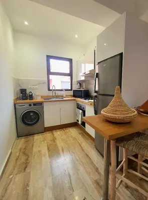 a kitchen with a washer and dryer and a table at Peaceful one terrace suite, gueliz in Marrakech
