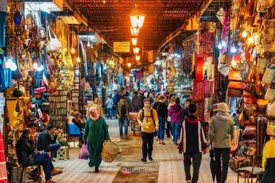 a group of people walking through a market in a city at Riad Loriental And Spa in Marrakech