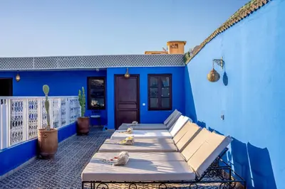 a row of beds sitting on a blue building at Riad les palmiers de la medina in Marrakech