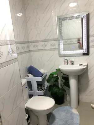 a bathroom with a sink and a toilet and a mirror at Appartement hay mabroka in Marrakech