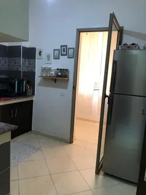 a kitchen with a refrigerator and a open door at Appartement hay mabroka in Marrakech