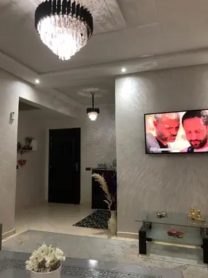 a living room with a tv on the wall at Appartement hay mabroka in Marrakech