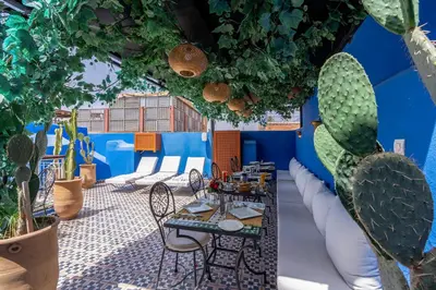 a patio with a table and chairs and cactus at Riad Jowara in Marrakech