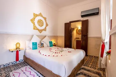 a bedroom with a large white bed in a room at Riad Jowara in Marrakech