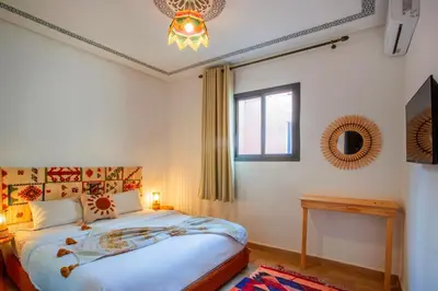 a bedroom with a bed and a window and a chandelier at Auberge Prince in Marrakech