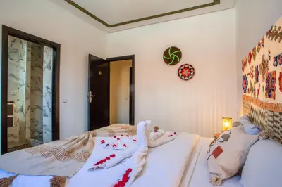a bedroom with two beds and a clock on the wall at Auberge Prince in Marrakech