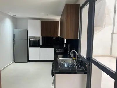 a kitchen with a sink and a refrigerator at Duplex Menara Garden 2 in Marrakech