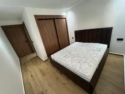a bedroom with a bed and two doors at Duplex Menara Garden 2 in Marrakech