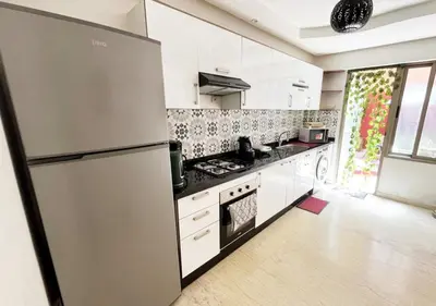 a kitchen with a stainless steel refrigerator and white cabinets at duplex prestige Gueliz in Marrakech