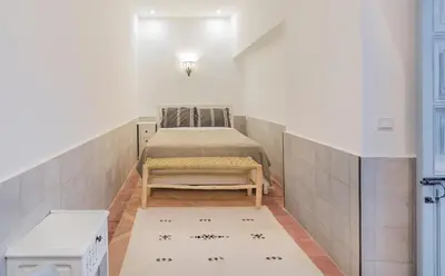 a small room with a bed and a rug at Riad HØBÖ-CHIC privé Medina rooftop WI-FI Fibre in Marrakech