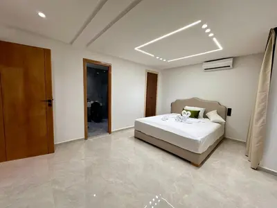 a bedroom with a bed in a room with a door at Chic duplex luxury3suites et wi-fi in Marrakech