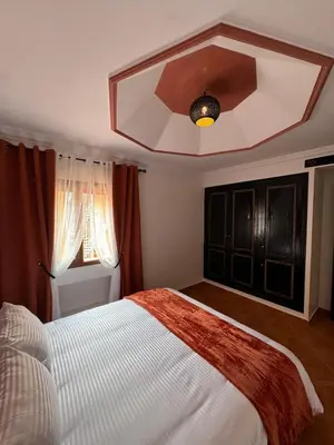 a bedroom with a large bed and a ceiling at Appartement typique Marrakech in Marrakech