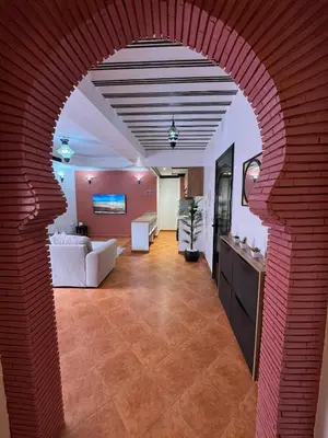 an archway in a living room with a red brick wall at Appartement typique Marrakech in Marrakech