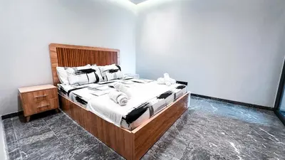 a bedroom with a large bed with a wooden headboard at Cocon Stylé & Spacieux au Cœur de Ville in Marrakech