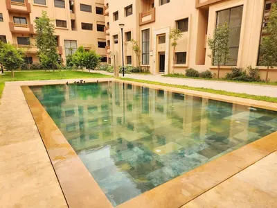 a swimming pool in front of a building at Bohemian Chic Apartment in Guéliz - Pool View in Marrakech