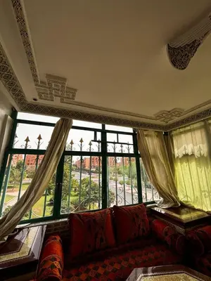 a living room with a couch and a large window at Appartement a louer a massira 3 marrakech in Marrakech
