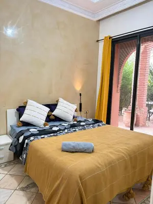 a bed in a room with a large window at Appart villa de luxe avec 5 piscines in Marrakech