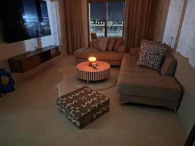 a living room with a couch and a table with a candle at Appart-by-Ily-Avenue M VI -Agdal in Marrakech