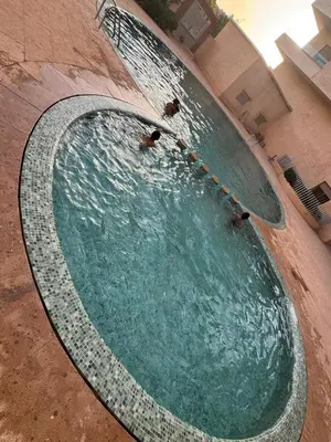a pool of water with people swimming in it at Appart-by-Ily-Avenue M VI -Agdal in Marrakech