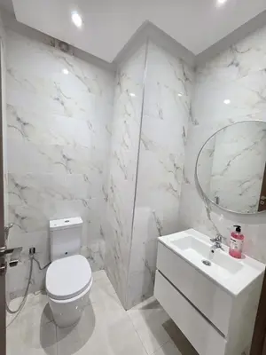 a white bathroom with a toilet and a sink at Appart-by-Ily-Avenue M VI -Agdal in Marrakech