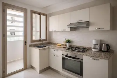 a kitchen with white cabinets and a stove top oven at Marrakech prestige in Marrakech